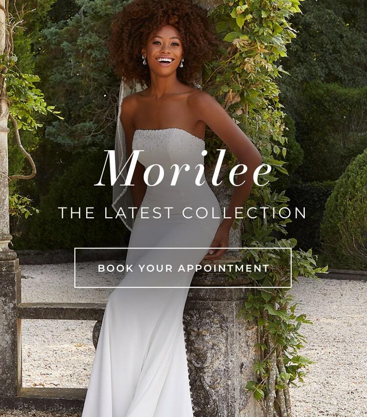 Woman wearing a Morilee wedding gown while standing in a garden